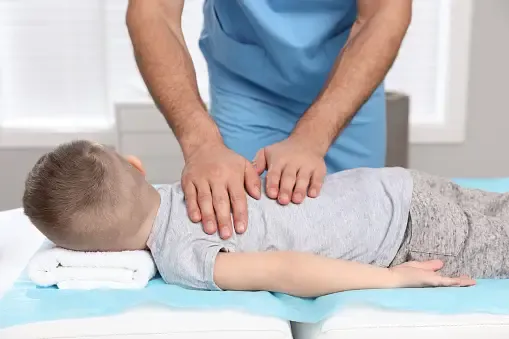 A child receiving a chiropractic adjustment